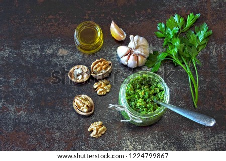 Walnut Pesto. Jar of pesto and ingredients. Cooking homemade walnut parsley pesto.