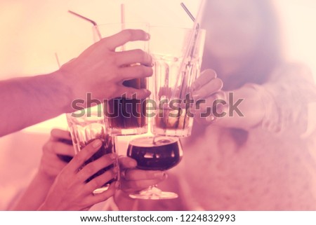Cheers clinking of friends  drink in party night after work on toned background