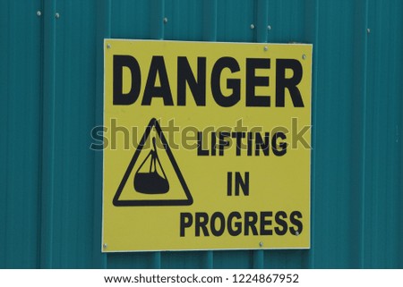 Danger: Lifting in Progress Sign at a construction site - centered