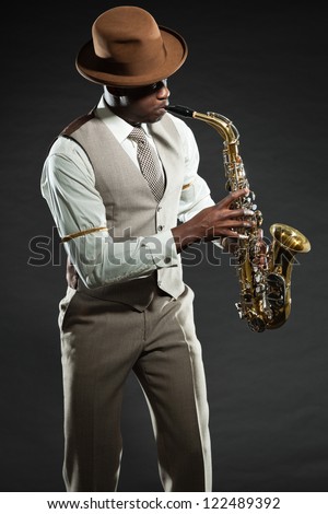 Black american jazz saxophone player. Vintage. Studio shot. Royalty-Free Stock Photo #122489392