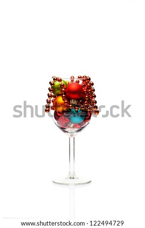 Multi-colored Christmas balls in a vine glass isolated on white.