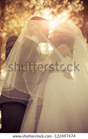 young bride and groom in the park, a wedding bouquet, wedding dresses