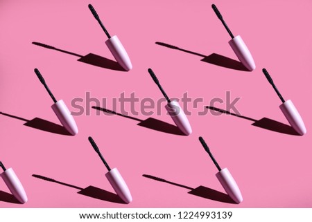 
many mascara brushes on a pink background hard light. seamless pattern