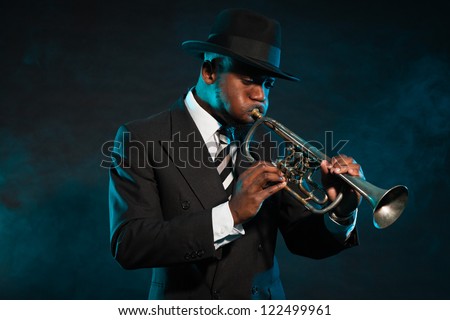 Black african american jazz trumpet player. Vintage. Studio shot. Royalty-Free Stock Photo #122499961