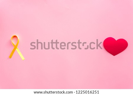 Endometriosis. Gynecological diseases concept. Symbolic yellow ribbon near heart sign on pink background top view copy space