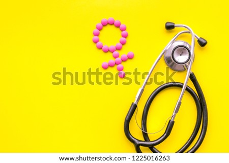 Female diseases concept. Stethoscope near female sign on yellow background top view copy space