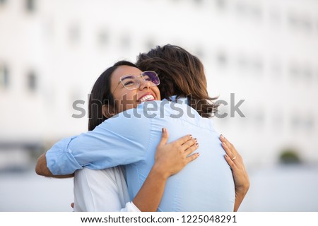 Attractive smiling Latin woman hugging man on urban street. Beautiful successful couple embracing in city. Togetherness concept Royalty-Free Stock Photo #1225048291