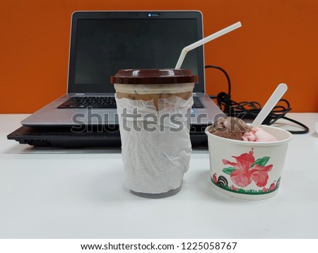 coffee and ice scream lay on office desk