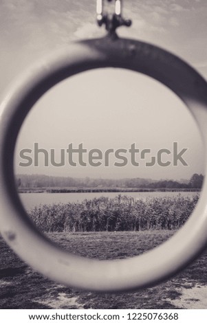 black and white view through circle on the lake and reeds