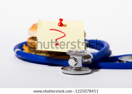 Burger with label, stethoscope, problem diagnosis