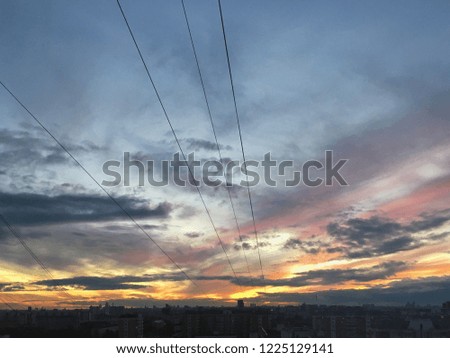 Photo with bright orange and purple sunset on a blue sky with clouds