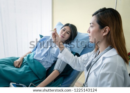 Team of doctor examining a female patient on bed in hospital