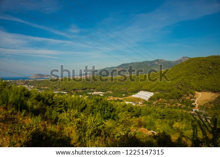 White green house on blue sky background. Plants crop in greenhouse. Closed rectangular greenhouse top view. Alanya, Turkey