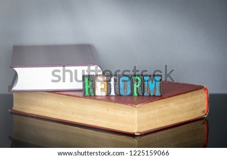 Reform word from colored wooden letters on gray background. Education and knowledge concept
