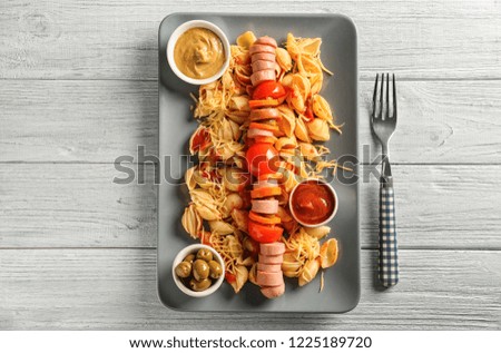 Delicious pasta with sausage and sauces on plate