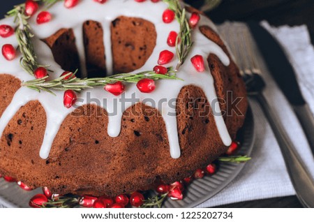 Homemade chocolate Christmas cake decorated with rosemary and pomegranate, front view