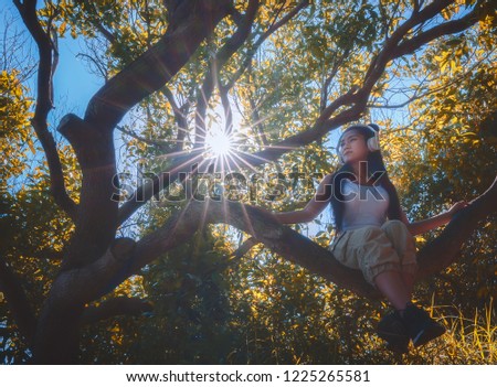 Young asian woman with headphone on the tree in the forest,hikers walking in the mountain.