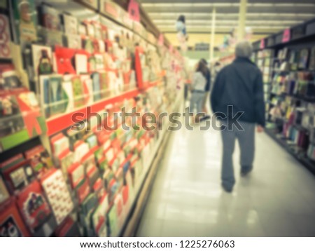Motion blurred customer shopping, selecting greeting cards at grocery store in Texas, America.