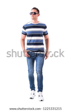 Handsome cool fit casual man with sunglasses walking with one thumb in pocket. Full body isolated on white background. 