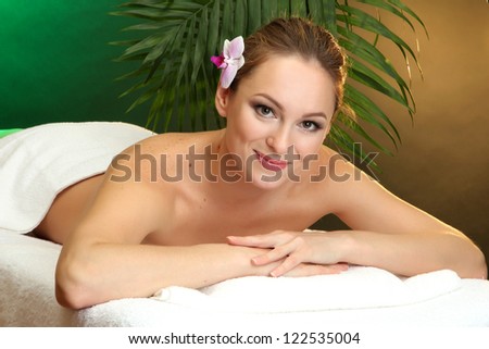 beautiful young woman in spa salon, on green background