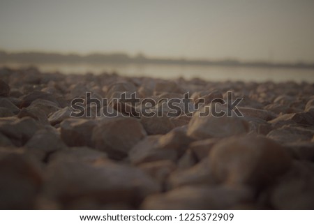 Blured picture of sharp sea stone beach with dark rocks