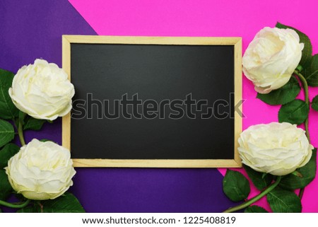 blackboard and bunch of peony flower on pink and purple background flat lay
