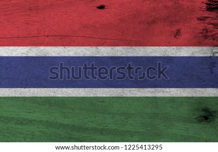 Flag of Gambia on wooden plate background. Grunge Gambian flag texture, red blue and green color and separated by a narrow band of white.