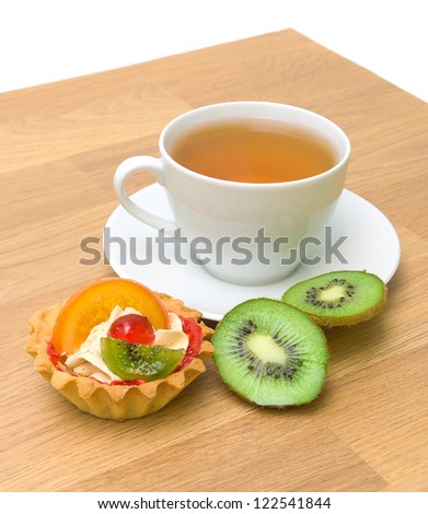 tart, ripe kiwi fruit and a cup of tea on a wooden board