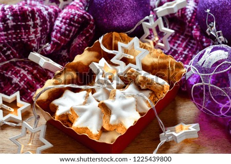 Christmas gingerbread star shaped cookies  and purple christmas decoration  and lights on wooden background. Christmas background. 