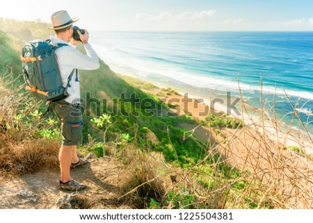 Man tourist with backpack are looking at the beautiful natural landscape of the sea on peak view