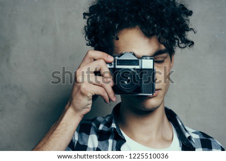 man holds a camera in front of his face                    