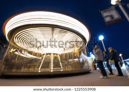 Abstract, long exposure shot of spinning Children's vintage Carousel at an amusement park in the evening and night illumination. Beautiful, bright carousel in Alicante, Spain  