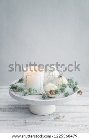 Tray with christmas decorations and candle on white wooden background closeup