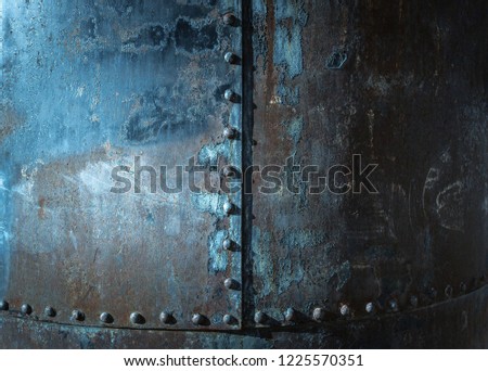A close up view of and industrial and aging bridge column with blue peeling paint.