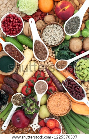 Health food for a high fibre diet with fruit, vegetables, legumes, nuts, seeds and cereals. Foods with antioxidants, anthocyanins, vitamins and minerals. Top view. Royalty-Free Stock Photo #1225570597