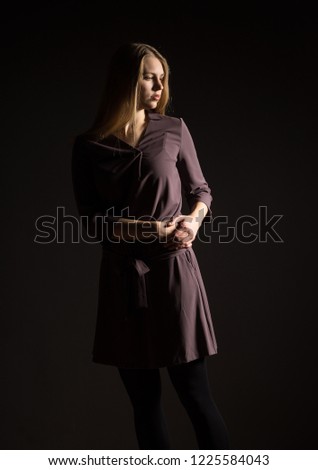 Caucasian white female model portrait. Beautiful girl, long blonde hair. Woman posing studio shot on a black background