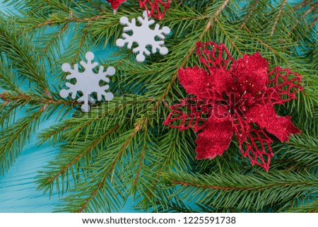 Close up fir branches and poinsettia flower. Poinsettia Christmas tree decoration. Christmas arrangement with spruce branches, white snowflakes and flower ornament.