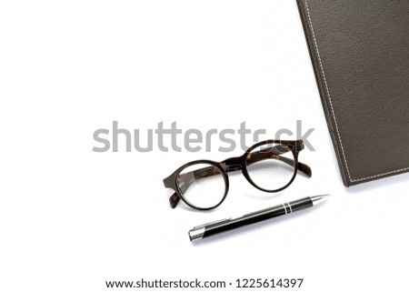 brown glasses and black pen on white background isolated