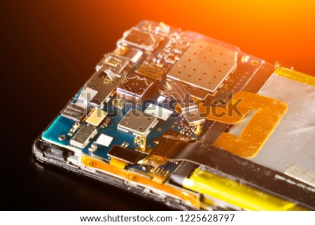 broken phone on a black background. Repair smartphone. Diagnostic center of service of cellular telephones. The electronic board
