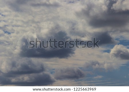 Large dark cumulus clouds in the blue sky