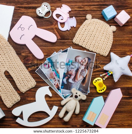 Mothers Day concept. Baby and mother pictures, clothes and toys on rustic wooden background. Top view, flat lay.