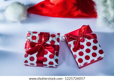 Red Santa hat wrapped present box on white surface.