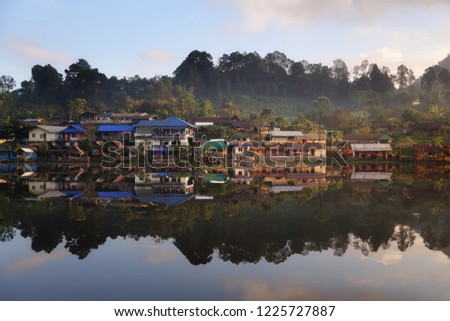 Beautiful scenery during sunrise with the mist and water reflection of the Chinese village at the Lee wine ruk thai lake, Mae Hong Son in Thailand is a very popular for photographers and tourists