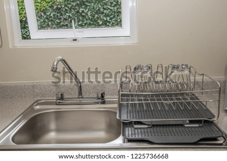 kitchen interior dishwasher, silver dish drainer for use in the kitchen with soft light and silver keys in modernist decoration