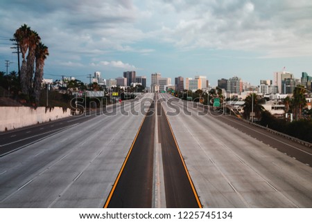 Horizontal landscape view of San Diego, California, USA Skyline with empty freeway in foreground. The 5 freeway travels most of the coast of the western united states and starts in San Diego.