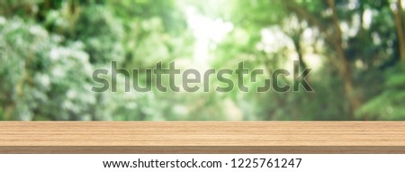 Wood table top and blur green forest for product and display montage banner size. Royalty-Free Stock Photo #1225761247