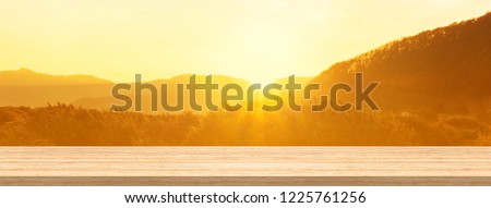 Wood table top and blur sunrise or sunset background for product and display montage banner size. Royalty-Free Stock Photo #1225761256
