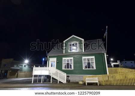 A green wooden house in Iceland at night