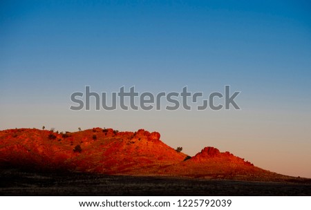 Early morning light is seen to hit a rocky outcrop in the Australian outback