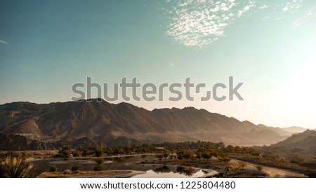 Camp site with a lagoon within the mountain range of Hatta, Dubai, UAE during the months of autumn with cloudy skies